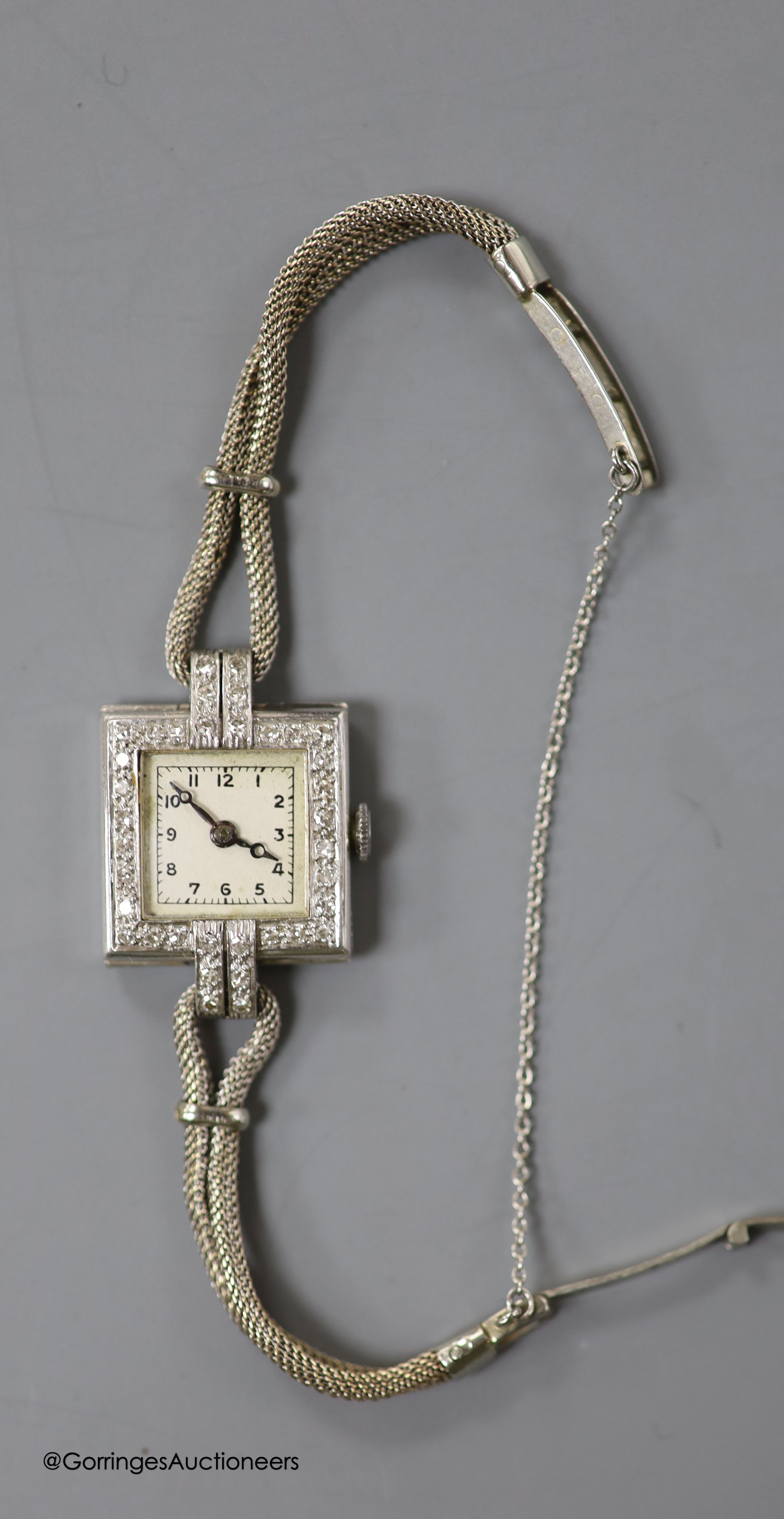 A lady's 1940's white metal (stamped platinum) and diamond set Vertex manual wind square dial cocktail watch, on a 9ct twin strand bracelet